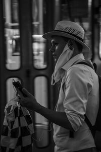 Side view of young man looking at camera