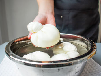 Cheese maker making mozzarella or buratta, hands holding buratta cheese, buratta cheese preparation