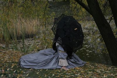 Man sitting on field in forest