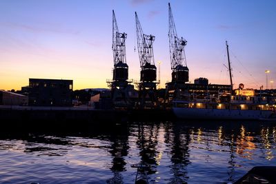 Sailboats in harbor against sky during sunset