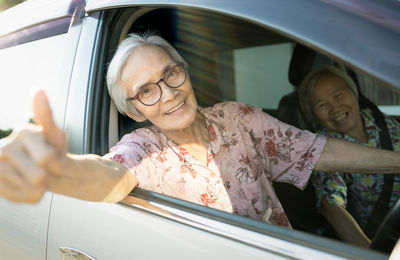 Portrait of woman with reflection on window in car