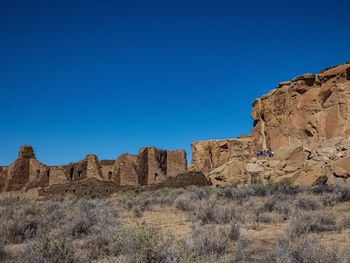 Rock formations on landscape against clear blue sky