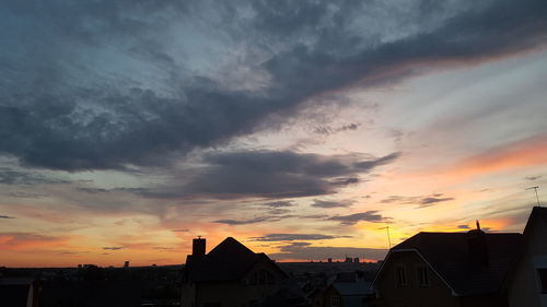 Houses against sky during sunset