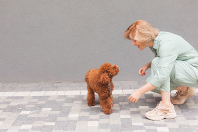 Full length of woman with dog on floor