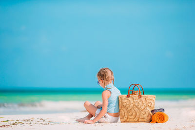 Full length of boy on beach against blue sky