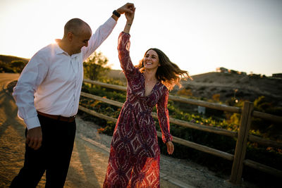 Husband and wife dancing at sunset in socal