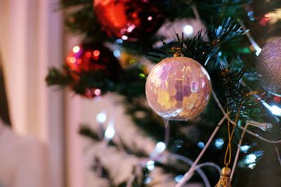 Close-up of shiny bauble hanging from christmas tree