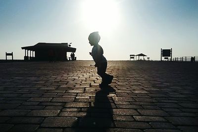 Silhouette of man on road against sky
