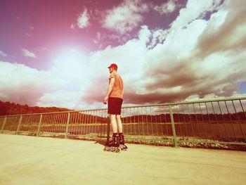 Man standing on bridge against sky