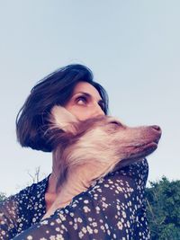 Portrait of young woman looking away against clear sky