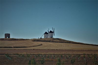 Windmill on field against clear sky