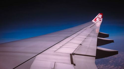 Low angle view of airplane flying against blue sky