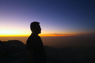 Silhouette man standing against sky during sunset