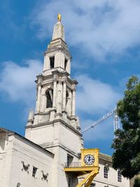 Low angle view of clock tower and building against sky