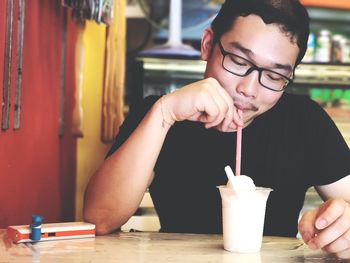 Man drinking milkshake at restaurant