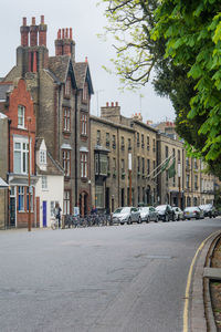 Street by buildings in city against sky