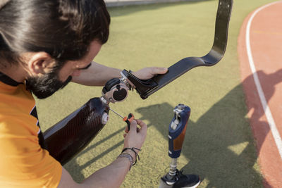 Athlete adjusting prosthetic leg with screwdriver