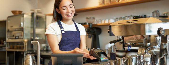 Portrait of young woman standing in cafe