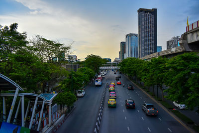 Cars on road amidst buildings in city against sky