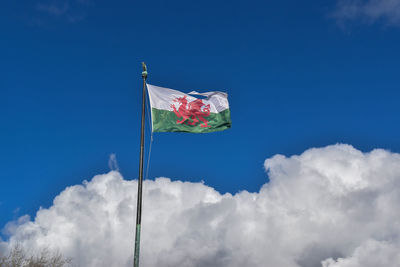 Low angle view of flag against blue sky