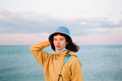 Portrait of woman standing in sea against sky