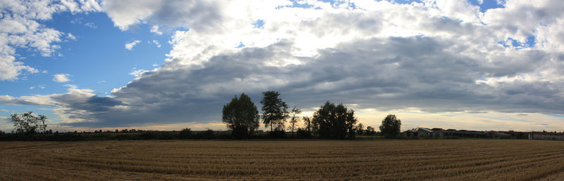 Scenic view of field against cloudy sky