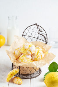 Cracked lemon cookies in small metal backed on white background. vertical composition