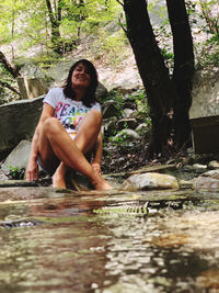 Portrait of young woman sitting in forest