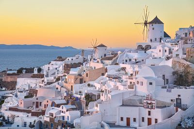 High angle view of townscape by sea against sky during sunset