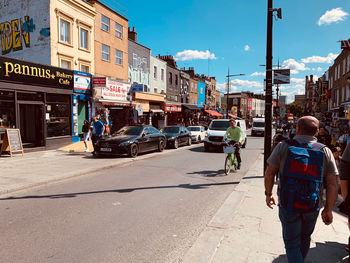 Rear view of people walking on city street