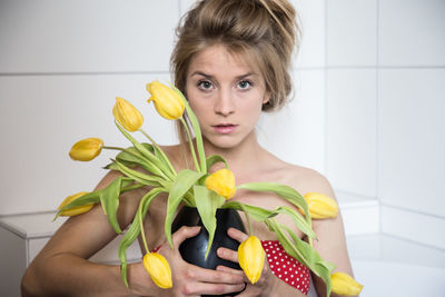 Portrait of young woman holding fruits