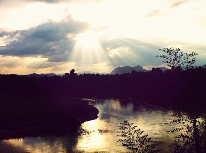 water, sun, silhouette, reflection, sunset, tranquil scene, scenics, sky, tranquility, lake, beauty in nature, sunbeam, sunlight, nature, tree, waterfront, idyllic, cloud - sky, mountain, lens flare