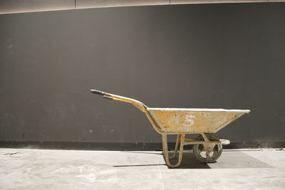 Close-up of wheelbarrow against wall