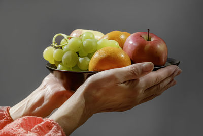 Cropped hand of man holding apples