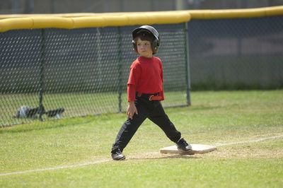 Young boy smirking on third base on the tball field
