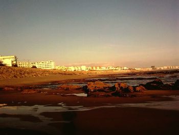 View of city at seaside during sunset