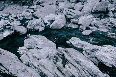 High angle view of people on rock in stream