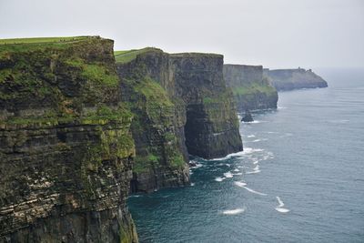 Rock formations by sea against sky