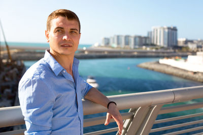 Mature man looking away while standing by railing
