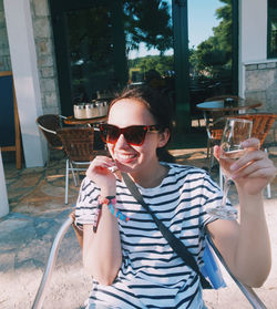 Portrait of smiling man drinking glass in sunglasses