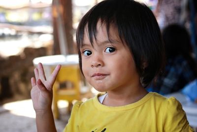 Close-up portrait of cute girl gesturing outdoors