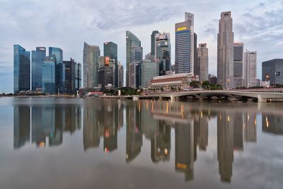 Reflection of buildings in city against sky