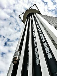 Low angle view of modern building against cloudy sky