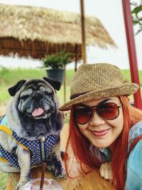 Portrait of woman in sunglasses with dog outdoors