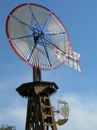 Low angle view of ferris wheel against blue sky