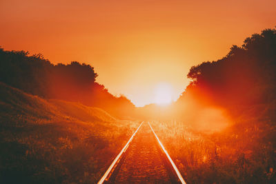 Panoramic view of railroad tracks against sky during sunset