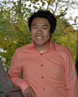 Portrait of smiling young man standing in balcony