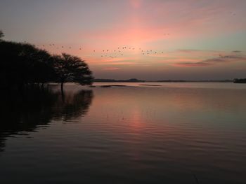 Scenic view of lake against sky at sunset