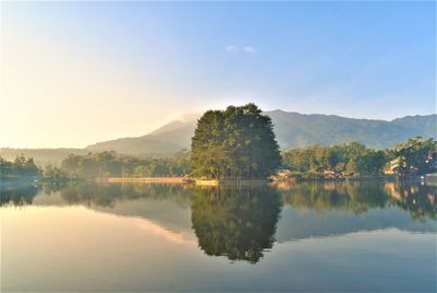 Scenic view of lake by trees against sky