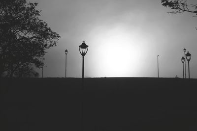 Low angle view of silhouette street light against sky